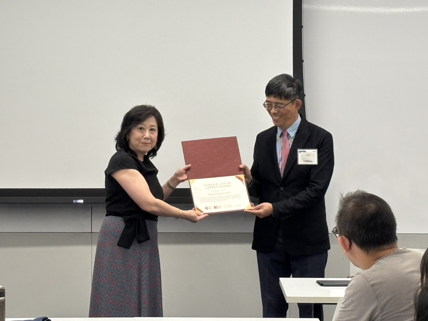 印永翔副校長代表臺師大頒贈感謝狀予哥倫比亞大學Zhaohong Han教授，表達對其在EMI教師增能課程投入的感謝，也象徵臺師大與哥大攜手打造國際教育合作典範的深厚情誼。